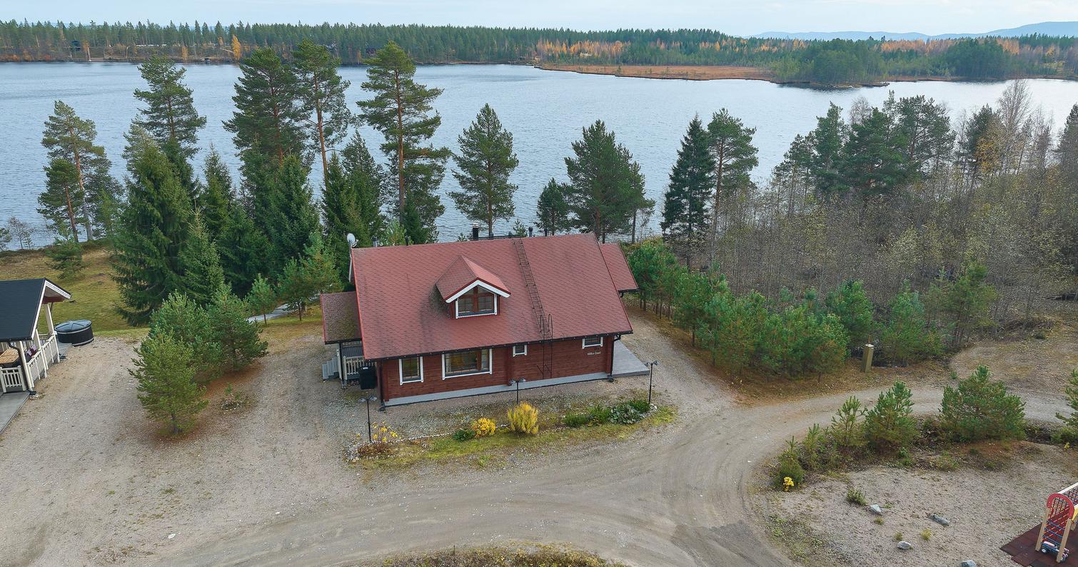 Ilmakuva punaisesta vuokramökistä Pielisen rannalla, ympärillä hiekkapolut ja vehreä metsä. Täydellinen majoitus Pohjois-Karjalassa.